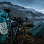 Road trip velo ecosse : vélo gravel chargé près d’un loch écossais, tente sur tourbe.