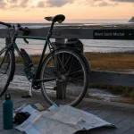 Visiter la basse normandie : vélo près du panneau Mont-Saint-Michel
